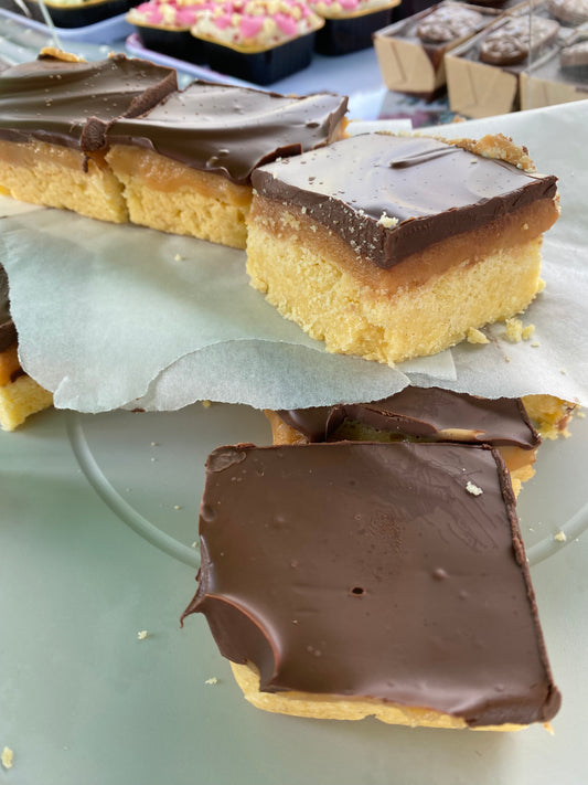A full traybake of caramel shortcake sliced and on display in two layers