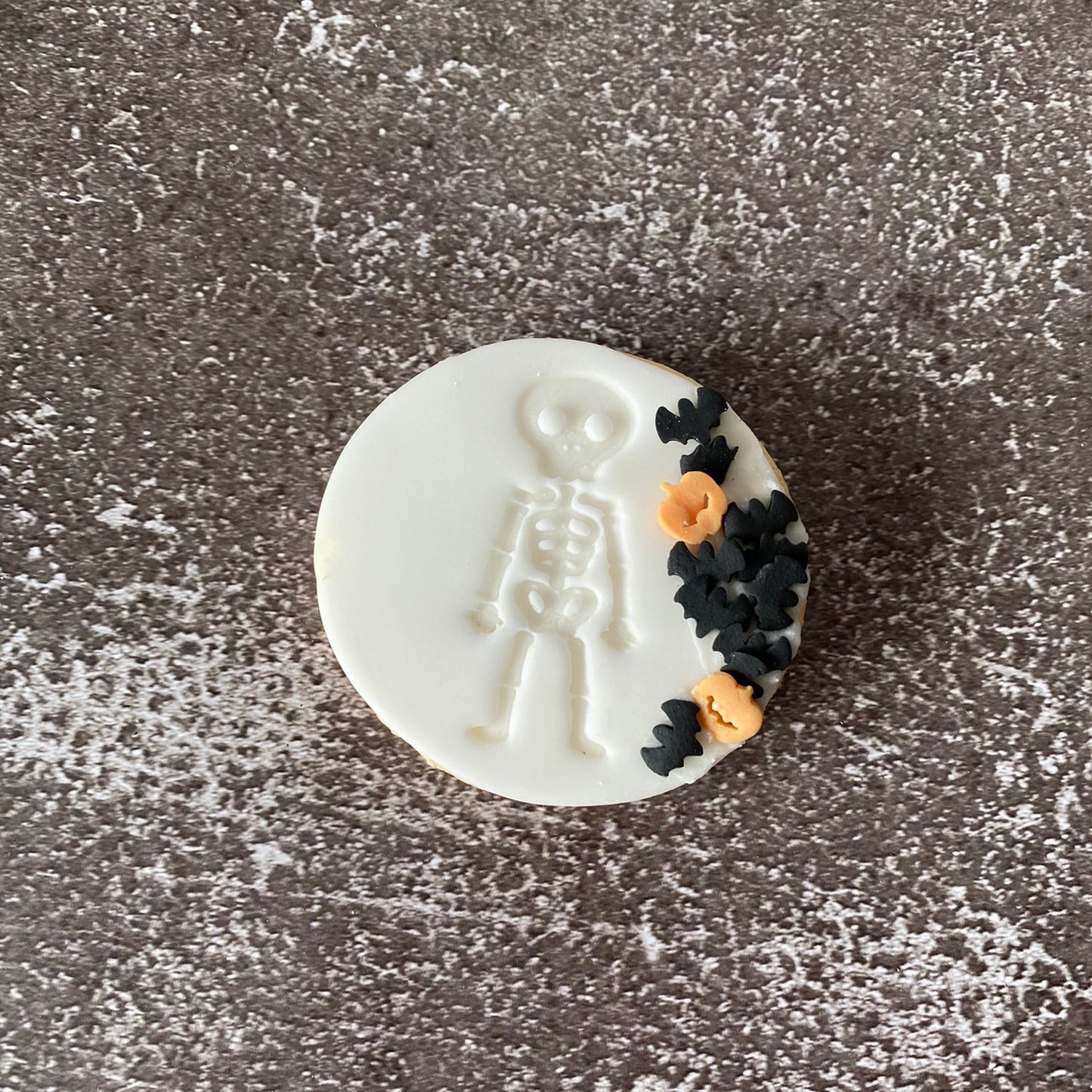 Decorative cookie with skeleton design on a textured surface