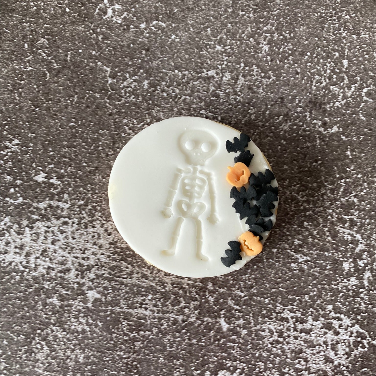 Decorative cookie with skeleton design on a textured surface